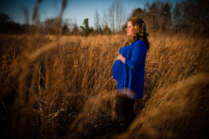 maternity photo standing in golden field